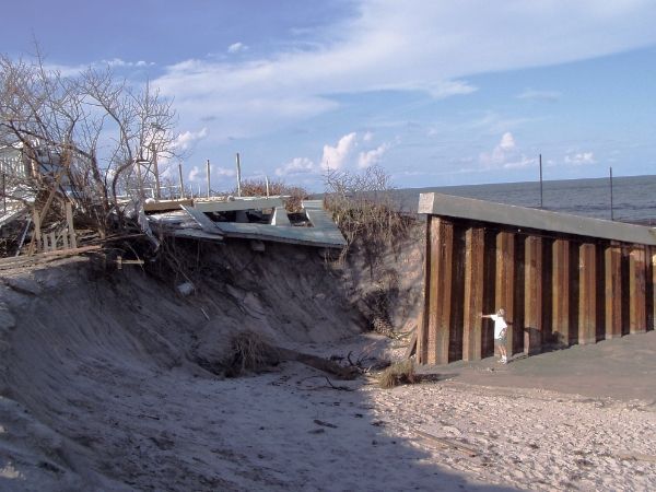 STC's Gary Appelson standing in front of an exposed sea wall in Brevard County after a hurricane. 